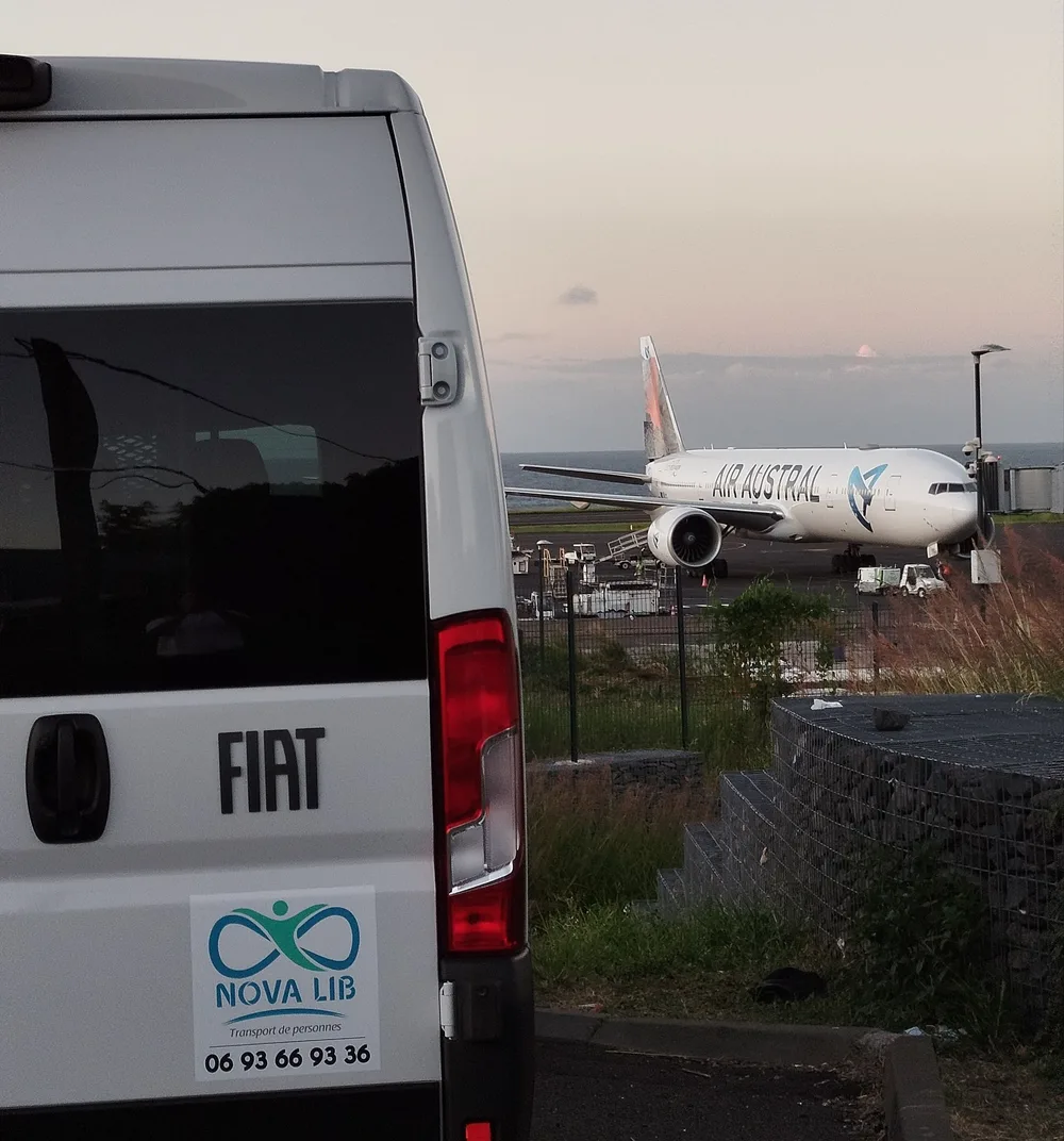 Van Nova Lib devant un avion à l'aéroport de La Réunion